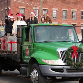 Cider Mill employees riding on the back of the Cider Mill flatbed truck for the annual Endicott Holiday parade on December 2, 2017